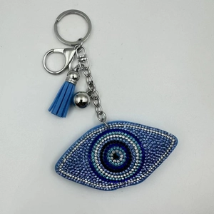 Detailed view of the sparkling rhinestone evil eye keychain with a blue tassel and silver clasp