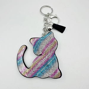 Détail macro du porte-clés chat en strass colorés avec pompon noir et fermoir argenté