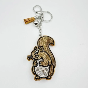 Macro detail of sparkly squirrel keychain with gold rhinestones and brown leather tassel