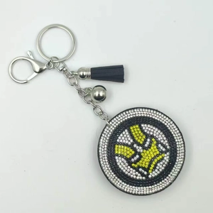 Detailed close-up of a volleyball rhinestone keychain with blue tassel and silver bell accessory