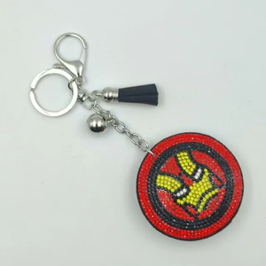 Sparkling rhinestone superhero keychain with black fringe and silver bell accessory