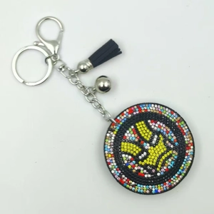 Superhero style rhinestone keychain with yellow V-gesture charm and black tassel