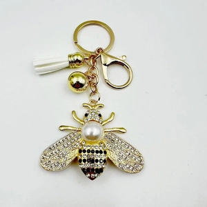 Fashionable golden bee keychain with sparkling crystals and a large pearl charm