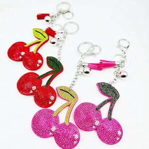 Detail of crystal cherry keychain with vibrant rhinestones, colorful tassels, and bells
