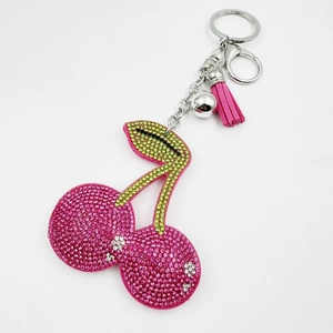 Close-up of cherry keychain with pink rhinestones, green leaves and pink leather tassel
