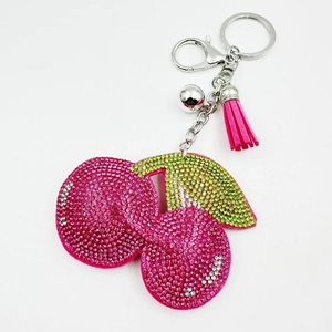 Détail du porte-clés cerise en cristal avec strass et pompon magenta assorti