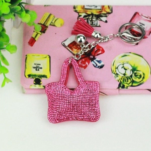 Vue détaillée du mini pendentif sac en strass rose avec pompon en cuir et porte-clés