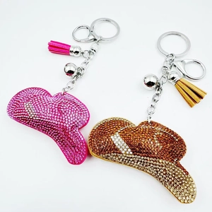 Detail of crystal studded cowboy hat keychain with leather tassel and metal bell