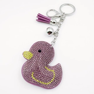 Detail of purple rhinestone duck keychain with tassel and silver bell accessory