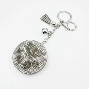 Sparkling rhinestone bear paw keychain with grey tassel and silver metal bell pendant