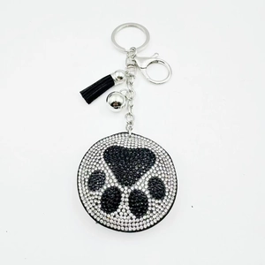 Close-up of paw print rhinestone keychain with black tassel and silver bell detail