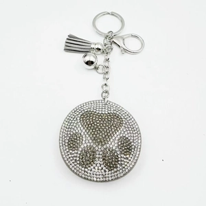 Sparkling rhinestone bear paw keychain with silver metal rings and grey tassel charm
