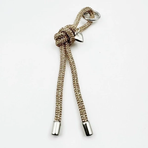 Close-up of champagne gold rhinestone drawstring charm with silver heart pendant and ring