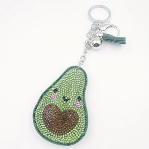 Dettaglio portachiavi avocado con strass, campanellino argento e nappa in pelle verde