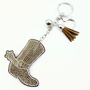 Detail of high-heel boot keychain with rhinestones, brown tassel, and silver bell charm