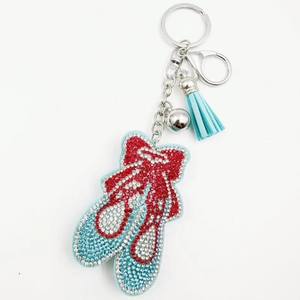 Dettaglio del portachiavi scarpette da ballo rosse con nappa blu e campanellino argento