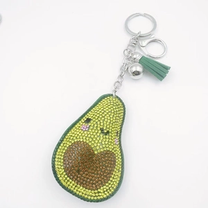 Dettaglio portachiavi a forma di avocado con strass luccicanti, nappa verde e moschettone