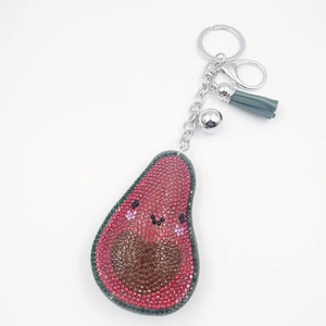Dettaglio portachiavi a forma di avocado con strass rosa e ciondolo nappa grigio