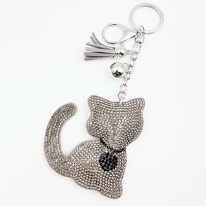 Detailed view of cat keychain with silver rhinestones, grey tassel, and bell accessory