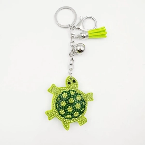 Vue détaillée porte-clés tortue avec strass verts et pendentif gland assorti