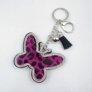 Close-up of leopard print butterfly keychain with rhinestones and black tassel charm