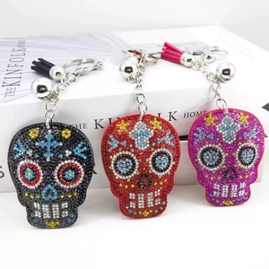 Detail view of skull keychains with crystal rhinestones, silver bells and tassel charms