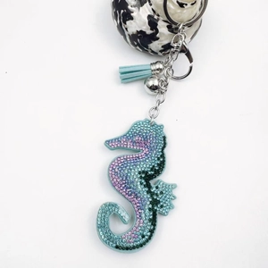 Sparkling crystal seahorse keychain with blue leather tassel and silver bell accessory