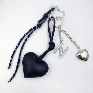 Detail of black heart PU leather keychain with rhinestone letter N and braided rope