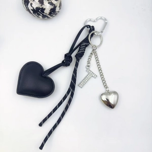 Detail of black PU leather heart pendant with rhinestone letter T and silver hardware