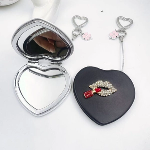 Vue détaillée d'un miroir de maquillage en cuir en forme de cœur avec lèvres en strass