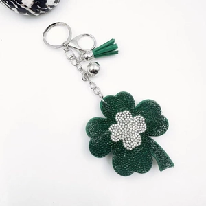 Detail of green four-leaf clover keychain with rhinestones and tassel hanging ornaments