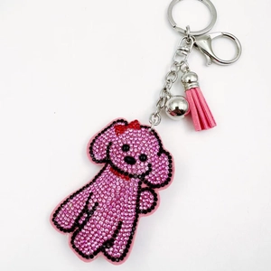 Porte-clés chiot en strass rose avec pompon en velours et accessoire cloche argentée