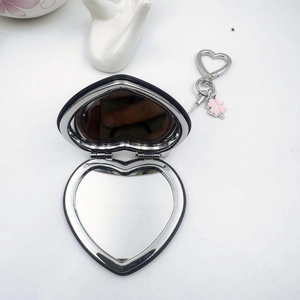 Vue détaillée du miroir de maquillage pliable en forme de cœur bleu avec porte-clés