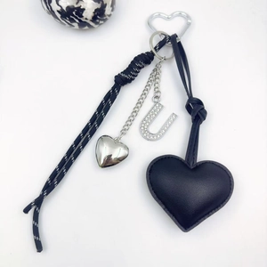 Detail of heart PU leather keychain with rhinestone letter U and polka dot woven strap