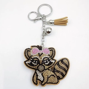 Détail du porte-clés raton laveur en strass avec fermoir argenté et pompon en cuir brun