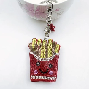 Close-up of rhinestone french fries keychain with leather tassel and silver bell detail