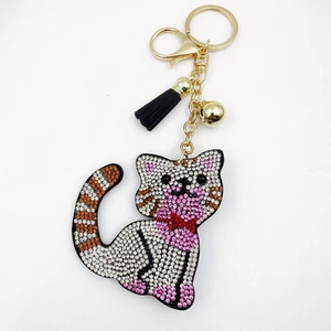Detailed view of crystal cat keychain with pink rhinestones, gold ring, and black tassel