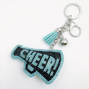 Blue rhinestone CHEER megaphone keychain with tassel and bell accessory on white background