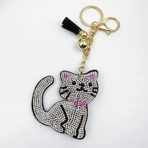 Sparkling crystal cat keychain with white rhinestones, pink bow, and black tassel decoration
