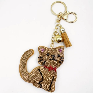 Macro shot of the champagne rhinestone cat keychain with a light brown tassel and gold clasp