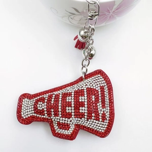 Macro detail of red megaphone keychain with rhinestones, CHEER lettering and red tassel