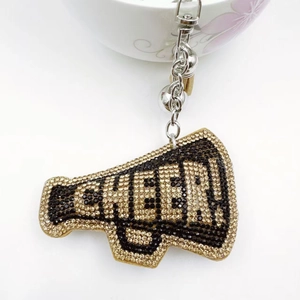 Detailed close-up of a rhinestone megaphone keychain with CHEER text and silver bell