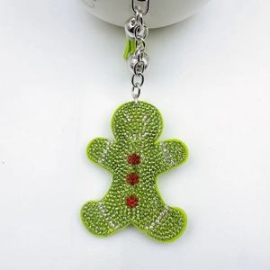 Close-up of gingerbread man keychain with light green rhinestones and silver bell
