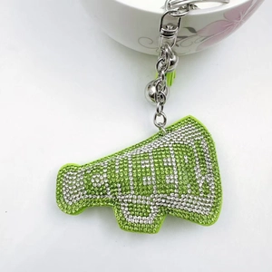 Macro detail of a green rhinestone megaphone keychain with silver CHEER text and tassel