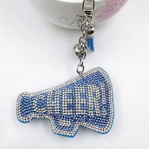 Detailed view of megaphone-shaped keychain with CHEER lettering in blue and white crystals