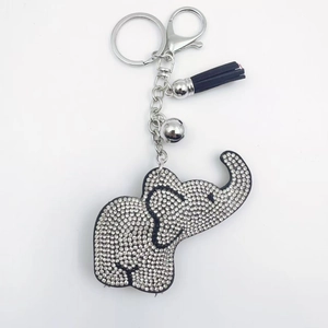 Porte-clés éléphant avec cristaux argentés, pompon bleu et clochette sur fond blanc pur