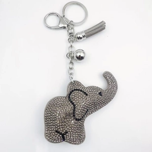 Détail du porte-clés éléphant avec strass brillants, pompon gris et clochette argentée
