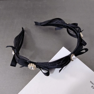 Elegant black satin bow headband with white faux pearls and gold rhinestone details