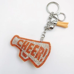 Macro detail of Cheer megaphone keychain with orange rhinestones and leather tassel
