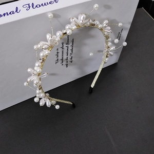 Detailed close-up of pearl and crystal flower headband with gold metal frame